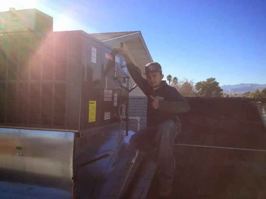 HVAC technician performing Air Duct Cleaning on a rooftop unit in New Windsor